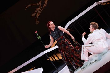 "Achill unter den Mädchen", KHP, Achill (Elmar Hauser) steht mit einer Rose in der Hand als Frau verkleidet vor dem am Boden sitzenden Odysseus (Isaac Tolley)